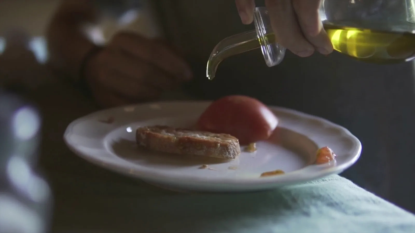 Cadru din filmul 3 Olives Society: ulei de măsline turnat peste pâine, măsline și roșii